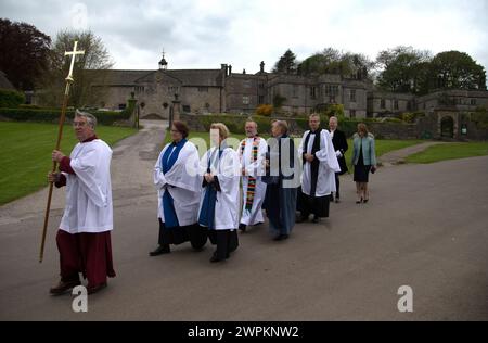 14/05/15 i membri del Clero processano dopo Tissington Hall. Per celebrare il giorno dell'ascensione, i vestiti di quest'anno sono svelati e benedetti dal cle locale Foto Stock