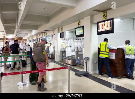 I passeggeri effettuano il check-in presso il terminal nazionale dell'aeroporto di Zanzibar, Zanzibar, Tanzania Foto Stock