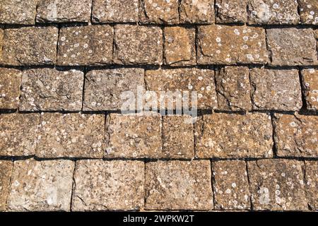 Un tetto in pietra realizzato con / ricoperto di pietre piastrellate di roccia calcarea sedimentaria, su una casa nel Cotswolds, Oxfordshire. Foto Stock