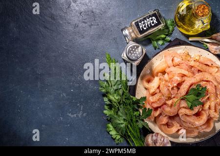 Dieta di cottura sfondo bianco di carne di pollame. Strisce di pollo fresche a fette crude per la cottura, con spezie, erbe aromatiche, su uno sfondo di cemento nero vista dall'alto c Foto Stock