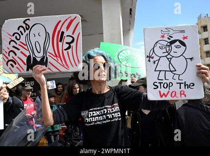 Tel Aviv, venerdì 8 marzo 2024. Tel Aviv, Israele. 8 marzo 2024. Una donna israeliana tiene dei cartelli in occasione di una protesta che chiede la fine della guerra di Hamas-Israele fuori dalla filiale dell'ambasciata degli Stati Uniti a Tel Aviv, venerdì 8 marzo 2024. I manifestanti hanno chiesto a Israele di far cadere cibo e non bombe per i palestinesi a Gaza. Foto di Debbie Hill/ credito: UPI/Alamy Live News Foto Stock