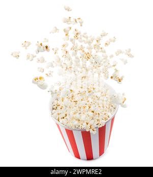 Popcorn che volano da un contenitore a strisce rosse e bianche, isolato su sfondo bianco. Foto Stock