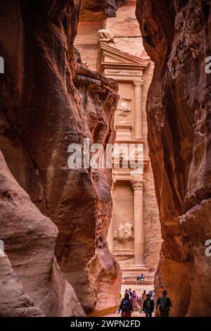 Ammira attraverso il Siq la casa del tesoro di Petra in Giordania, Medio Oriente, Asia Foto Stock