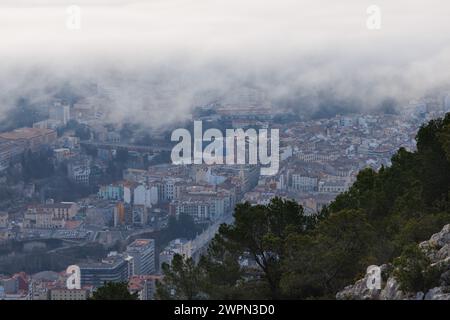 La città di Alcoy sotto una coltre di nuvole in inverno da Alt de les Pedreres, Spagna Foto Stock