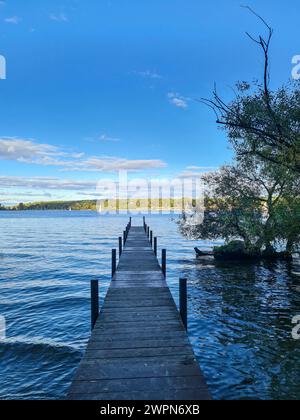 Vista del cielo azzurro all'orizzonte soleggiato dall'ombreggiato ponte pedonale in primo piano della foto, Wannsee, Berlino, Germania Foto Stock