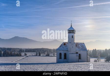 Germania, Baviera, Pfaffenwinkel, Penzberg, St Johannisrain, paesaggio invernale con St. La chiesa di Johannisrain, ai piedi delle Alpi Foto Stock