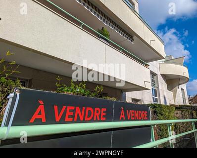 "A vendre" (traduzione inglese: "In vendita") scritto in francese su cartelli fissati all'esterno di un appartamento in un edificio residenziale Foto Stock