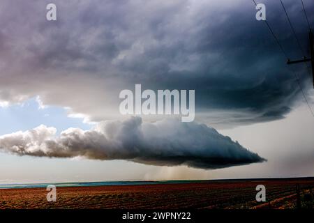 Un'enorme nuvola di tornado incombe su una fattoria deserta in Texas Foto Stock