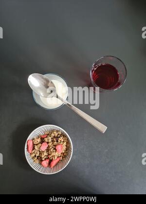 Una ciotola di muesli di grano con fragole e due bicchieri di succo e latte tra cui scegliere Foto Stock