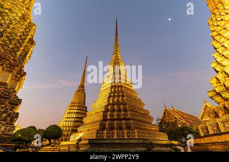 Chedis nel tempio buddista Wat Pho al crepuscolo, Bangkok, Thailandia, Asia Foto Stock