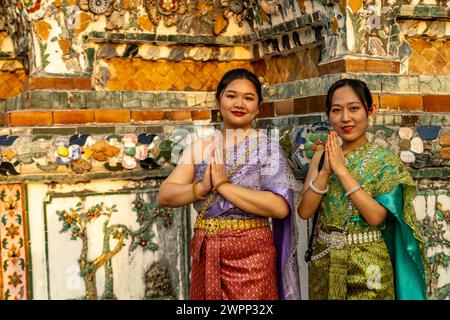 Le donne vestite in modo tradizionale posano di fronte al tempio Wat Arun o Tempio dell'Alba a Bangkok, Thailandia, Asia Foto Stock