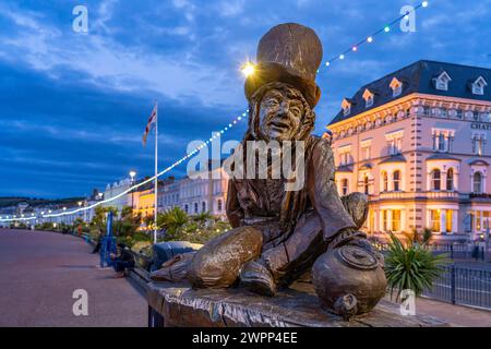 Scultura del Cappellaio Matto o Cappellaio Matto di Alice nel Paese delle meraviglie sulla passeggiata della località balneare di Llandudno al crepuscolo, Galles, Gran Bretagna, Europa Foto Stock