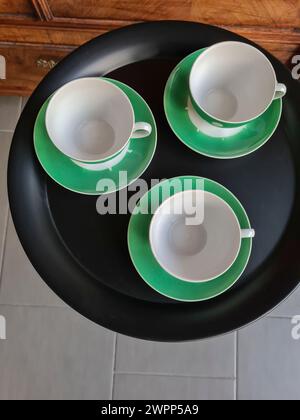 Vista dall'alto di tre tazze di caffè vuote su un tavolo rotondo nero Foto Stock