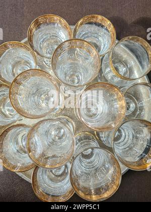 Vista dall'alto di una disposizione di ottimi bicchieri da vino e bicchieri da champagne con bordi dorati su un vassoio d'argento Foto Stock