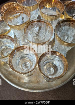 Vista dall'alto di una disposizione di ottimi bicchieri da vino e bicchieri da champagne con bordi dorati su un vassoio d'argento Foto Stock