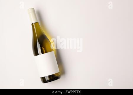 Bottiglia di vino gustoso su sfondo bianco, vista dall'alto. Spazio per il testo Foto Stock