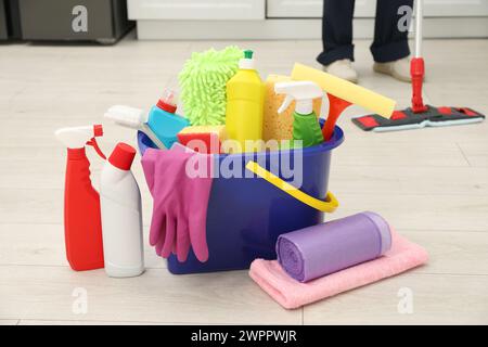 Diversi materiali di pulizia in secchio e uomo per la pulizia dei pavimenti, messa a fuoco selettiva Foto Stock