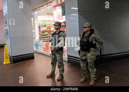 Membri delle guardie nazionali visti di pattuglia al Port Authority Bus Terminal di New York l'8 marzo 2024. Dopo un picco di violenza nel sistema, il governatore Kathy Hochul chiese alle guardie nazionali e un ulteriore numero di polizia da dispiegare nel sistema. Foto Stock
