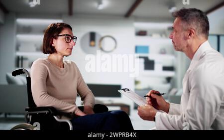 Medico e paziente femminile in sedia a rotelle a domicilio Foto Stock
