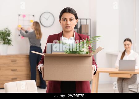 Problema di disoccupazione. Donna con scatola di effetti personali in ufficio Foto Stock