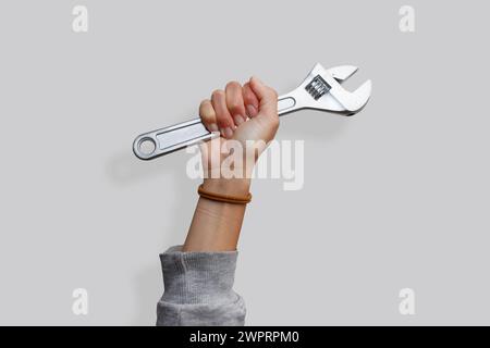 Mano di donna che tiene una chiave su uno sfondo bianco isolato. Mostrando l'emancipazione femminile Foto Stock