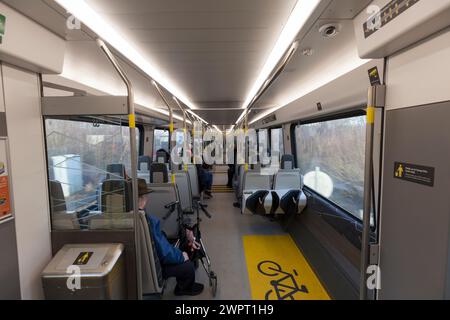 Interno di un treno elettrico Merseyrail classe 777 costruito da Stadler con passeggeri a bordo Foto Stock