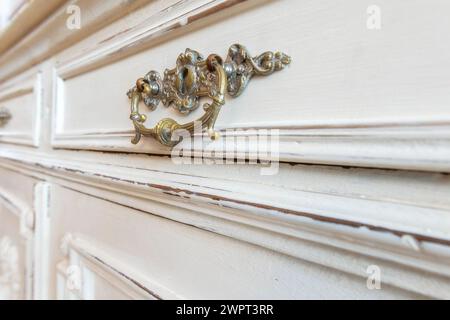 Manico vintage in ferro su cassetto bianco antico, interno della stanza della casa, primo piano Foto Stock