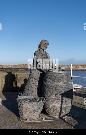 The Herring Girl - Fisher Wives - statua di Fisher Lass sul molo di Harbour West, Whitby, Yorkshire, Inghilterra Foto Stock