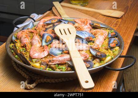 Paella di pesce pronta per essere servita con una spatola di legno sul tavolo, cucina tipica spagnola, Maiorca, Isole Baleari, Spagna Foto Stock