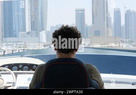 Uomo contemplativo con vista sulla Marina di Dubai. Dubai, Emirati Arabi Uniti - 15 agosto 2023 Foto Stock