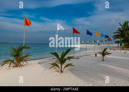 Spiaggia di sabbia bianca con molte bandiere, isola di Bangaram, arcipelago di Lakshadweep, territorio dell'Unione dell'India Foto Stock