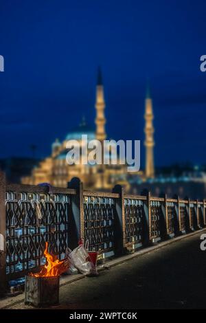 La mattina presto e il fuoco di un pescatore con la nuova Moschea (Yeni Cami) a Istanbul, Turchia Foto Stock