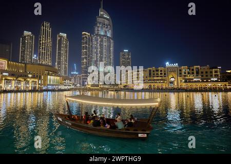 Dubai, Emirati Arabi Uniti, AsiaTourists cavalcano in barca di fronte al grattacielo sullo sfondo del lago Burj Khalifa Foto Stock