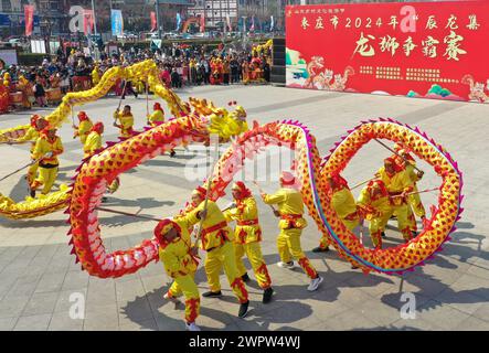 Zaozhuang, la provincia cinese di Shandong. 9 marzo 2024. Gli artisti folk danno uno spettacolo di danza drago nella città di Zaozhuang, nella provincia di Shandong della Cina orientale, 9 marzo 2024. Si sono svolte varie celebrazioni per il prossimo Longtaitou Day, una giornata tradizionale per un nuovo taglio di capelli dopo il Festival di primavera. Il giorno di Longtaitou, che letteralmente significa "drago solleva la testa", cade il secondo giorno del secondo mese lunare. Crediti: Song Haicun/Xinhua/Alamy Live News Foto Stock