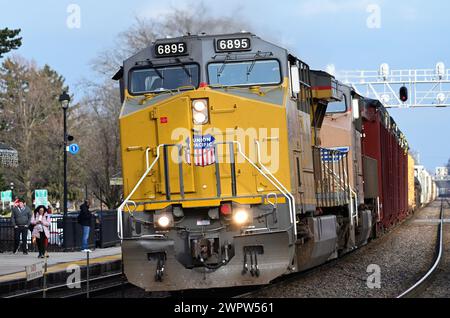 Glen Ellyn, Illinois, Stati Uniti. Le locomotive guidano un treno merci della Union Pacific Railroad oltre una stazione ferroviaria pendolare nella periferia di Chicago. Foto Stock