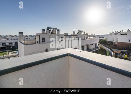 una grande terrazza vuota nell'attico di una casa residenziale in un'urbanizzazione con molte altre case identiche Foto Stock