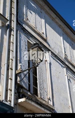 Europa, Francia, Nouvelle-Aquitaine, Saintes, lampione con bracketing e finestre con persiane in Rue Berthonnière Foto Stock