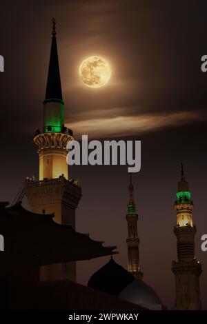 Una moschea con la luna piena nel cielo. Masjid nabi di Medina, moschea di notte. Masjid nabi di Medina. Cupola verde e luna... Foto Stock