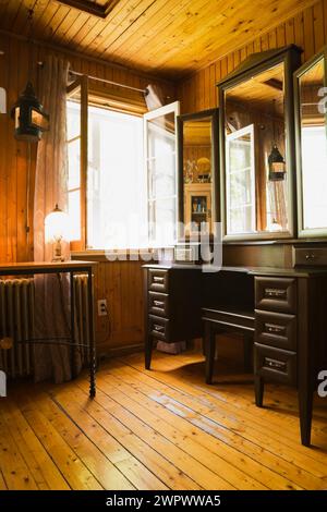 Ampia finestra aperta nella toilette illuminata con toletta al piano superiore all'interno di una vecchia casa degli anni '1920. Foto Stock