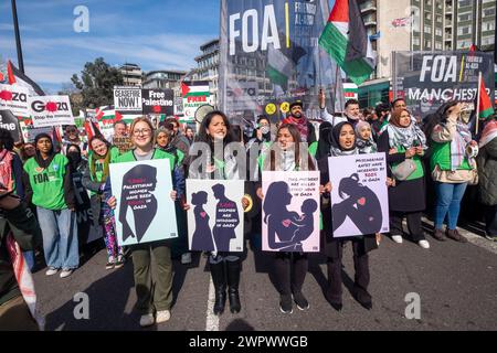 Londra, Regno Unito. 9 marzo 2024. Le donne tengono manifesti sulle sofferenze delle donne palestinesi. Un'enorme marcia pacifica verso l'ambasciata degli Stati Uniti richiede un cessate il fuoco a Gaza e la fine del genocidio israeliano. L'IDF ha ora ucciso oltre 30.000 persone, soprattutto donne e bambini, continuano a ignorare la sentenza della Corte di giustizia per evitare il genocidio e preparare un brutale assalto a Rafah. Israele continua a fermare gli aiuti umanitari e le forniture mediche necessarie per evitare morti di massa per malattie e fame e diffonde bugie sull'UNRWA, il cui finanziamento è essenziale. Peter Marshall/Alamy Live News Foto Stock