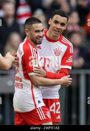 MONACO DI BAVIERA, GERMANIA - 09 MARZO: Jamal Musiala del Bayern Muenchen celebra il gol di 5:1 con Raphael Guerreiro del Bayern Muenchen durante la partita di Bundesliga tra FC Bayern München e 1. FSV Mainz 05 all'Allianz Arena il 9 marzo 2024 a Monaco, Germania. © diebilderwelt / Alamy Live News Foto Stock