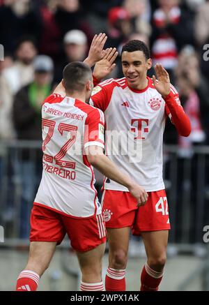 MONACO DI BAVIERA, GERMANIA - 09 MARZO: Jamal Musiala del Bayern Muenchen celebra il gol di 5:1 con Raphael Guerreiro del Bayern Muenchen durante la partita di Bundesliga tra FC Bayern München e 1. FSV Mainz 05 all'Allianz Arena il 9 marzo 2024 a Monaco, Germania. © diebilderwelt / Alamy Live News Foto Stock