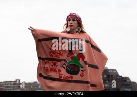 Londra, Regno Unito. 9 marzo 2024. Una donna che indossa il tradizionale copricapo palestinese e lo scialle decorato si erge sul ponte Vauxhall mentre decine di migliaia di sostenitori palestinesi marciano verso l'ambasciata degli Stati Uniti chiedendo un cessate il fuoco e la fine del sostegno del Regno Unito e degli Stati Uniti all'assedio, al bombardamento e all'invasione di Gaza da parte di Israele. Sotto blocco dal 2007, Gaza è stata descritta dal Segretario generale delle Nazioni Unite Antonio Guterres come "un cimitero per bambini”. Crediti: Ron Fassbender/Alamy Live News Foto Stock