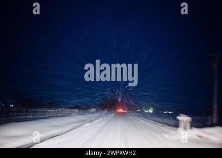 Forti tempeste di neve che guidano di notte, velocità di deformazione Foto Stock