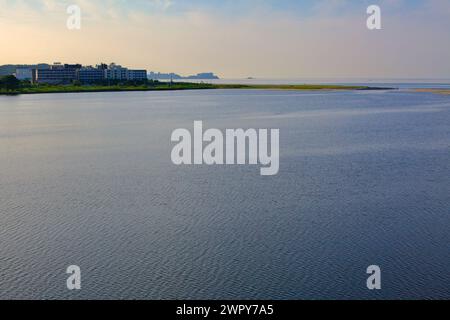 Contea di Yangyang, Corea del Sud - 30 luglio 2019: Una pittoresca vista del tramonto sul fiume Namdae di Yangyang, dove le acque calme incontrano il Mare Orientale, fiancheggiato dal caldo Foto Stock