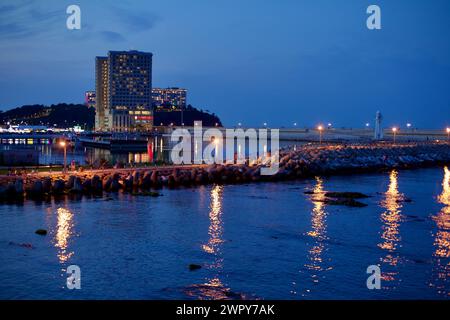 Sokcho City, Corea del Sud - 30 luglio 2019: Una serena vista serale del porto di Daepo, con la sua grande frangia che si estende nel mare, un piccolo faro Foto Stock