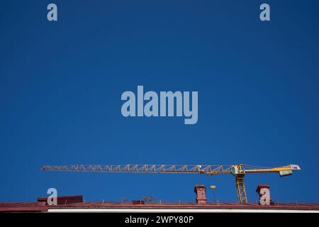 Bucarest, Romania - 3 marzo 2024: Una gru può essere vista sopra un cantiere. Questa immagine è solo per uso editoriale. Foto Stock