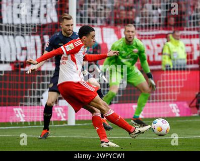 Monaco, Germania. 9 marzo 2024. Jamal Musiala (davanti) del Bayern Monaco passa il pallone durante la partita di calcio tedesca di prima divisione tra Bayern Monaco e FSV Mainz 05 a Monaco, Germania, 9 marzo 2024. Crediti: Philippe Ruiz/Xinhua/Alamy Live News Foto Stock