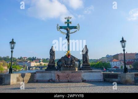 Statua del Santo Crocifisso e del Calvario sul Ponte Carlo, a Praga, Repubblica Ceca, nelle giornate di sole Foto Stock