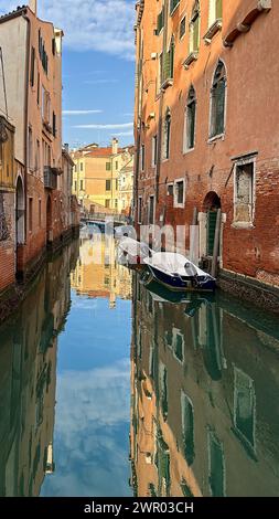 Case riflesse sulla superficie dell'acqua di un corso d'acqua di Venezia. Foto Stock